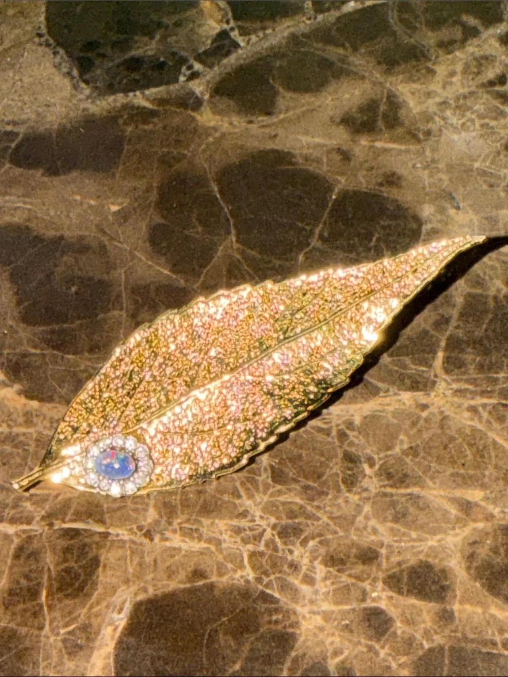 Beautiful gold plated leaf with a cabochon opal and crystal surrounding